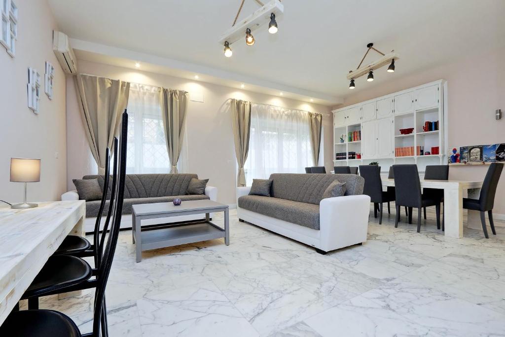 Bright open living room with marble floors, twin sofas and dining table at BALDO 190